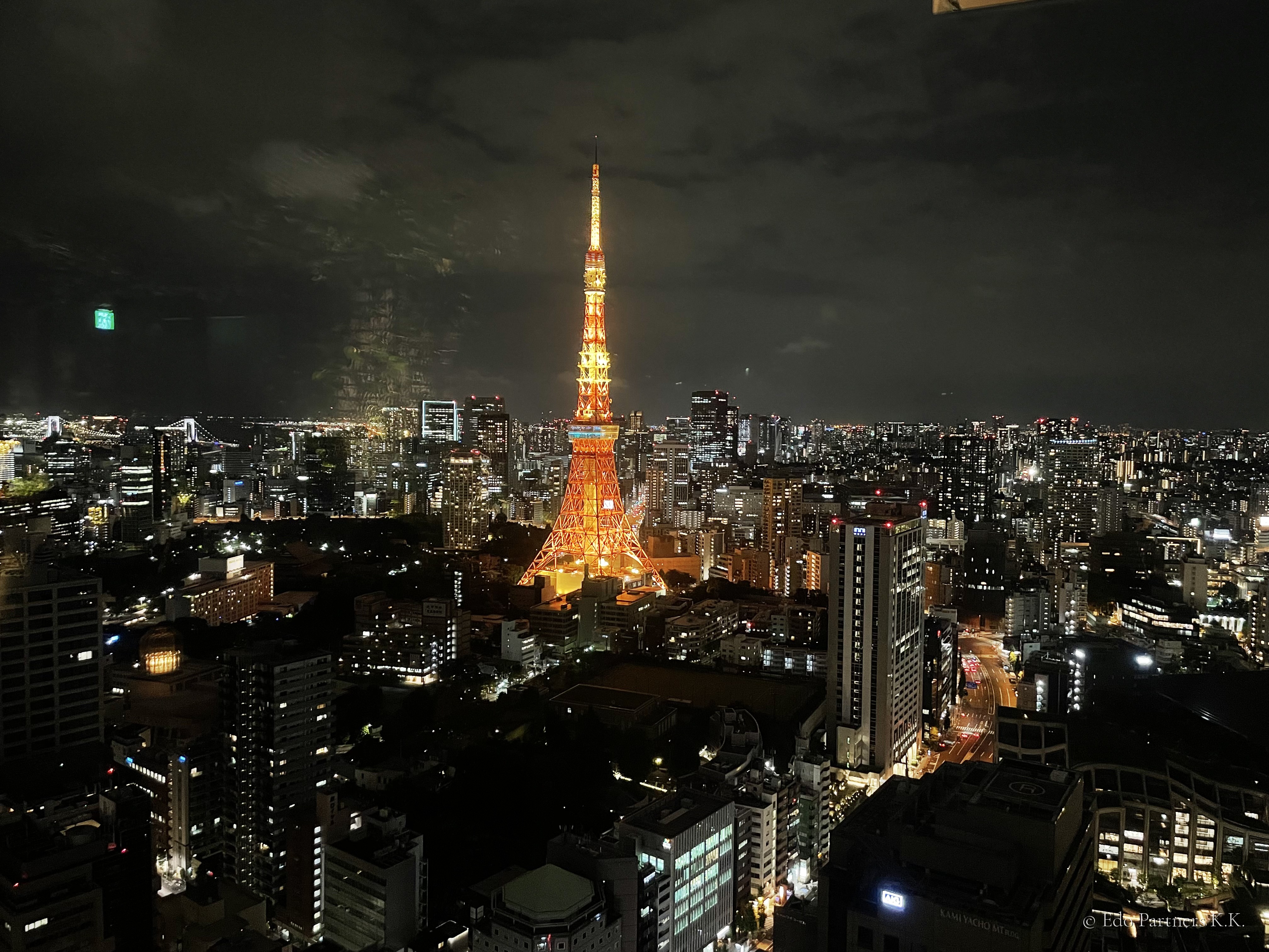 Tokyo Tower and the city skyline at night, seen from a high floor near Toranomon